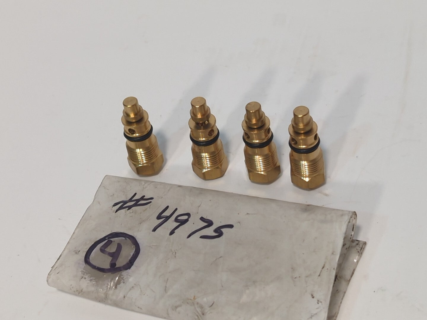 Lot of 4 brass check valves or possibly stems, marked 4975